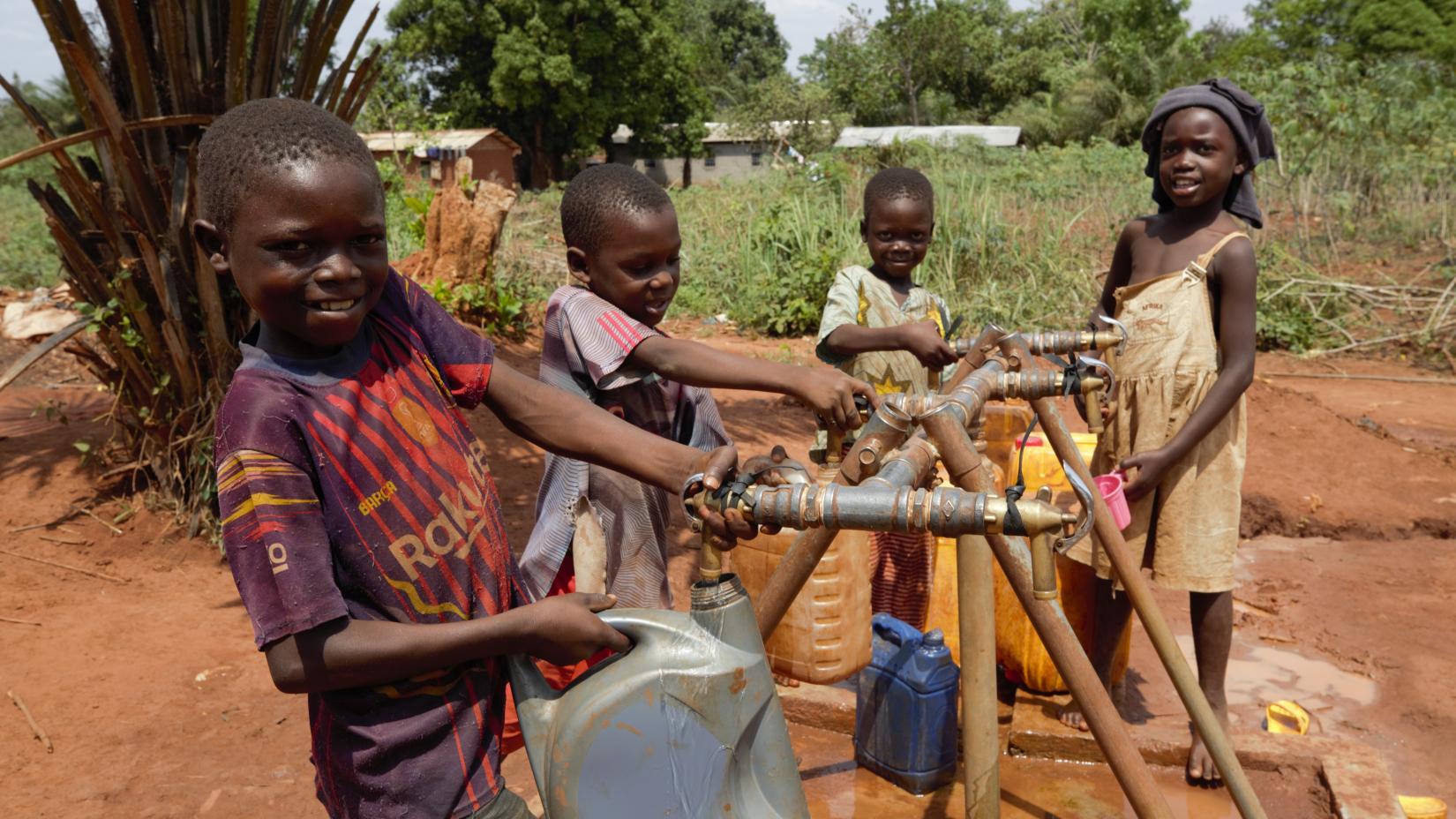 Des enfants remplissant des bidons au quartier Babili dans la commune de Begoua. 